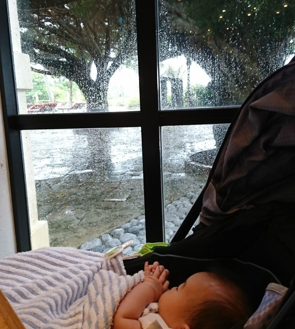 雨の沖縄を眺める赤ちゃん