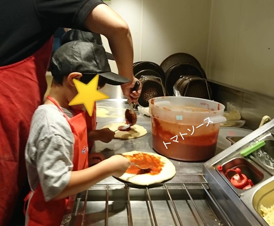 ドミノピザのピザアカデミー・ピザ生地にトマトソースを塗る