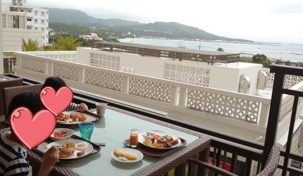沖縄本島北部にあるアラマハイナコンドホテルの朝食をオーシャンビューのテラス席で食べる子ども達