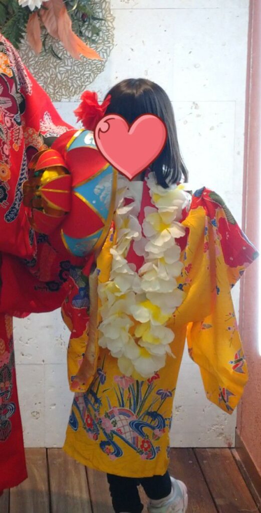沖縄の海洋博公園内にある琉装体験で琉球衣装を着る7歳