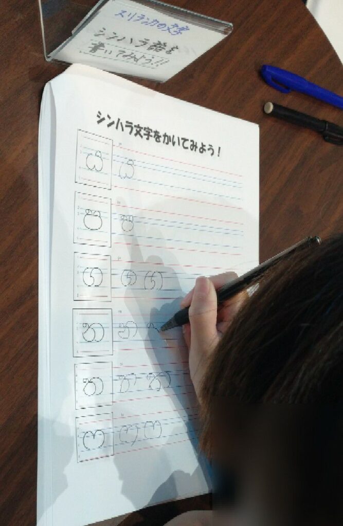 大阪・関西万博のコモンズA館にて。スリランカの文字『シンハラ文字』をかいてみよう！のコーナー。